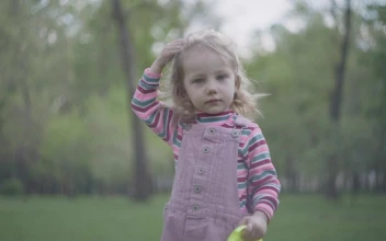 Stock Video Little Girl With Oversized Crown Plays In Park Animated Wallpaper
