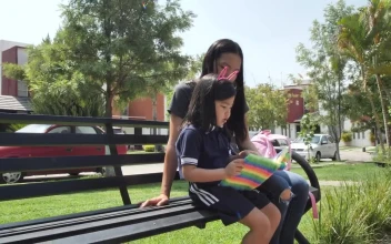 Stock Video Little Girl With Her Mom Reading Together In A Park Animated Wallpaper