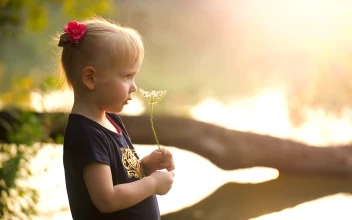 Stock Video Little Girl Smelling A Flower In Nature Animated Wallpaper