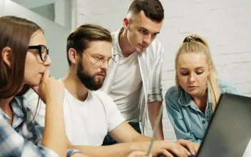 Stock Video Leader Types On Laptop While Team Look Over Shoulder Animated Wallpaper