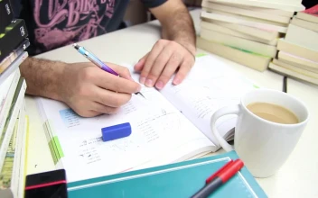 Stock Video Man Studying With A Cup Of Coffee And Many Book Animated Wallpaper