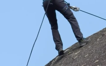 Stock Video Man Slowly Descending Rocky Mountai Animated Wallpaper