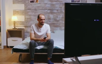 Stock Video Man Sits On Bed Laughing At Comedy On T Animated Wallpaper
