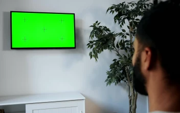 Stock Video Man Points Remote At Green Screen Tv On Wal Animated Wallpaper