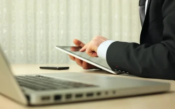 Stock Video Man In Suit Using A Tablet Next To His Compute Animated Wallpaper