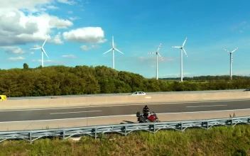 Stock Video Motorcycle On The Highway With A Wind Farm Behind