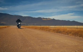 Stock Video Motorcyclist Crossing A Dirt Road In A Desert