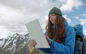 Stock Video Mountaineer Using A Tablet On A Mountain