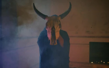 Stock Video Mysterious Person In Robe Holding A Bulls Skull