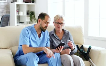 Stock Video Nurse Helps Woman Use App On Mobile Phone