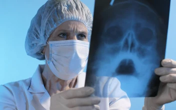 Stock Video Old Female Doctor Looking At An X Ray Wearing Face Mask