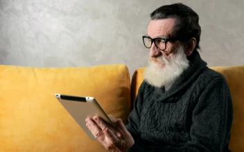 Stock Video Old Man Answers Mobile Phone Call While On Tablet At