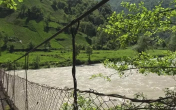 Stock Video Old Suspended Wooden Bridge Over A River