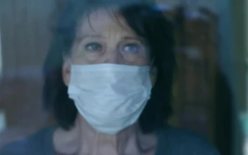 Stock Video Old Woman Looks Out The Window Wearing Mask