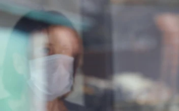 Stock Video Old Woman With Mask Looks Out The Window