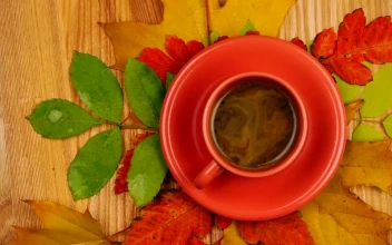 Stock Video Orange Colored Cup With Coffee With Autumn Leaves In The
