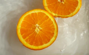 Stock Video Orange Half Spinning While Floating In Water
