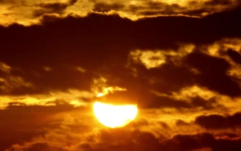 Stock Video Orange Sunrise Against Black Clouds