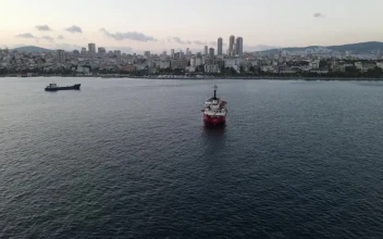 Stock Video Pair Of Cargo Ships Sailing Near A Coastal Town