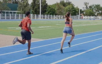 Stock Video Pair Of Man And Woman Athletes Running On A Track