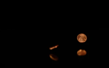 Stock Video Pennies Falling On A Reflective Surface With A Dark Background