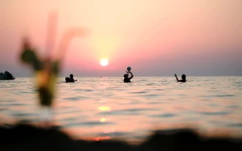 Stock Video People Playing Ball In The Ocean At Sunset