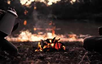Stock Video People Pouring A Warm Drink Around A Campfire
