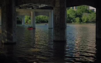 Stock Video People Rowing In A River Under A Large Bridge Large