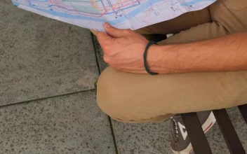 Stock Video People Sitting On The Street Reviewing A Map Together
