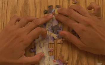 Stock Video Person Building A Puzzle On A Table