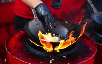 Stock Video Person Cooking In A Wok Pan With High Flame