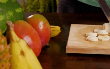 Stock Video Person Cutting Banana For A Fruit Cocktail