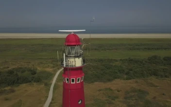 Video Stock Red Lighthouse Near The Shore Spinning Aerial Shot Free