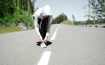 Free Stock Video Runner Ties Laces Before Starting Jog On Mountain Road