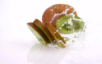 Free Video Stock Slices Of Kiwi Falling Into Water On White Background
