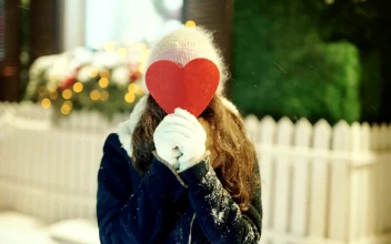 Free Video Stock Smiling Woman Covers Face With Heart Cutout In Snowy Street