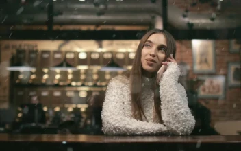Free Video Stock Smiling Woman Watches Snowfall While On Mobile In Cafe