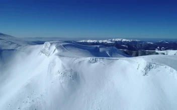 Free Video Stock Snowy Mountain Range Seen On A Clear Sky Day