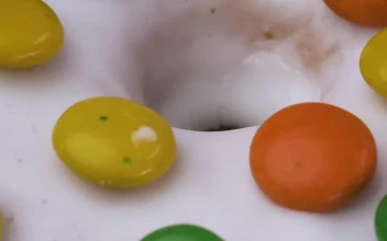 Free Video Stock texture of a glazed donut with colorful chocolates rotating