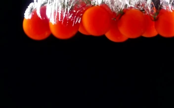 Free Video Stock tomatoes falling through water black background