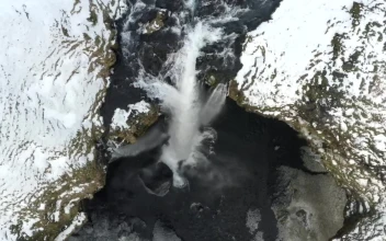 Free Video Stock top aerial shot of a waterfall in a winter forest