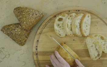 Free Video Stock top view of hands cutting fresh bread on wood board