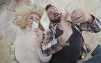 Free Video Stock top view of rich couple on rug laying in money