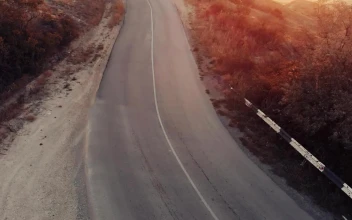 Free Stock Video Woman Jogging Down A Road Seen From The Air