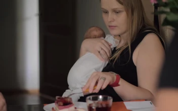 Free Stock Video Woman Eating Breakfast While Holding Her Baby