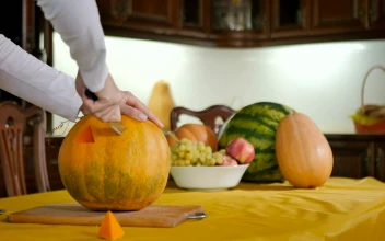Stock Footage Woman Carves Pumpkin Into Jack O Lantern On Kitchen Table