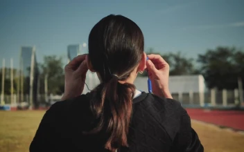 Stock Footage Woman Adjusting Her Headphones To Start Running