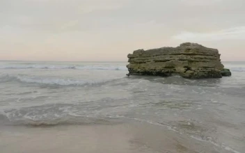 Stock Footage Waves Breaking Against A Large Rock Small