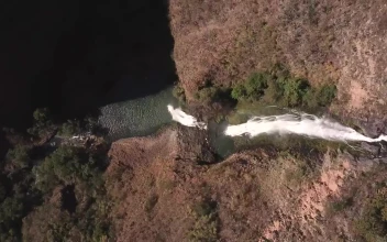 Stock Footage Waterfall Between Red Rocks And Trees