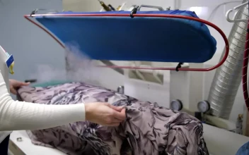 Stock Footage Using A Steam Cleaner On A Dress